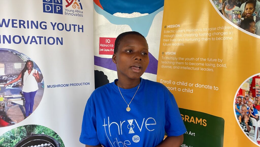 A young woman in a ThriveTribe 360 T-shirt speaks during a session.